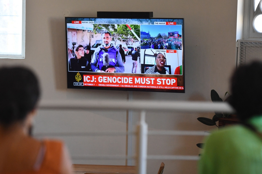 People gather to watch the International Court of Justice (ICJ) ruling of the case against Israel brought by South Africa in The Hague at the Bertha House in Cape Town on January 26, 2024. — AFP pic