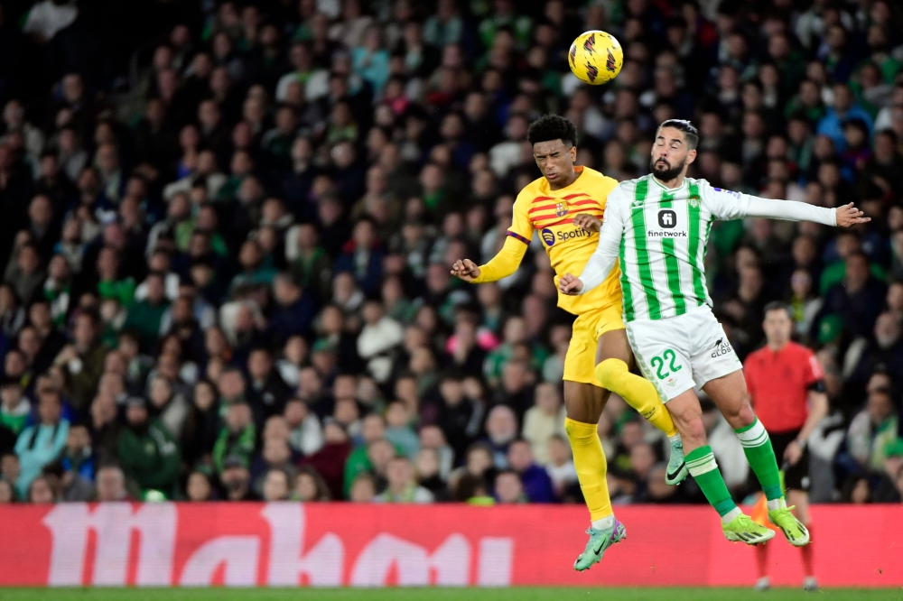 File photo of Barcelona’s Spanish defender #03 Alejandro Balde and Real Betis’ Spanish midfielder #22 Isco vieing for a header during the Spanish League football match between Real Betis and FC Barcelona at the Benito Villamarin stadium in Seville on January 21, 2024. — AFP pic