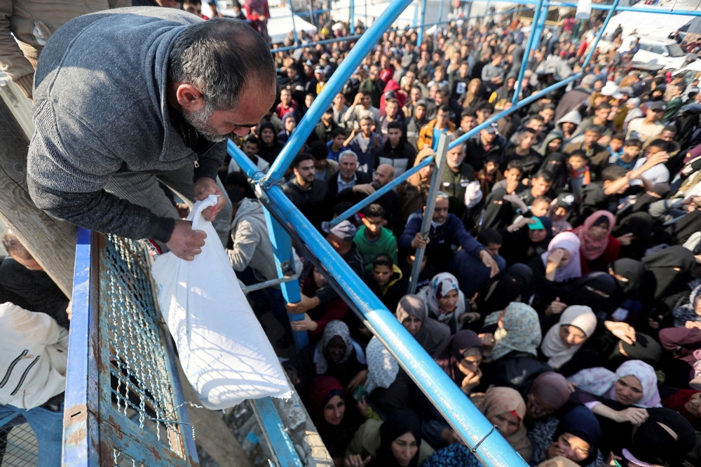The United Nations Relief and Works Agency handing out bags of flour to the people in Gaza. — Reuters pic