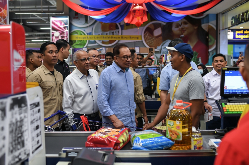 Prime Minister Datuk Seri Anwar Ibrahim speaks to a recipient of the Sumbangan Asas Rahmah (SARA) subsidy programme in Mydin Meru Raya, Ipoh January 28, 2024. — Bernama pic