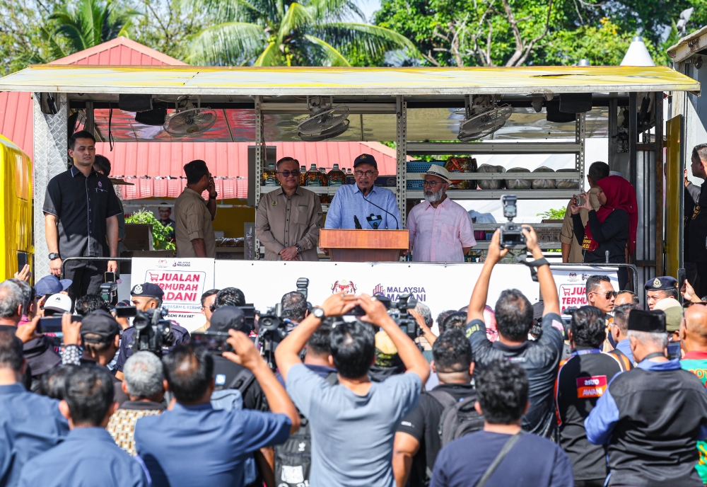 Prime Minister Datuk Seri Anwar Ibrahim speaks at the sales programme at the Klebang Restu which was also attended by Bukit Gantang Member of Parliament Datuk Syed Abu Hussin Hafiz Syed Abdul Fasal (right). — Bernama pic