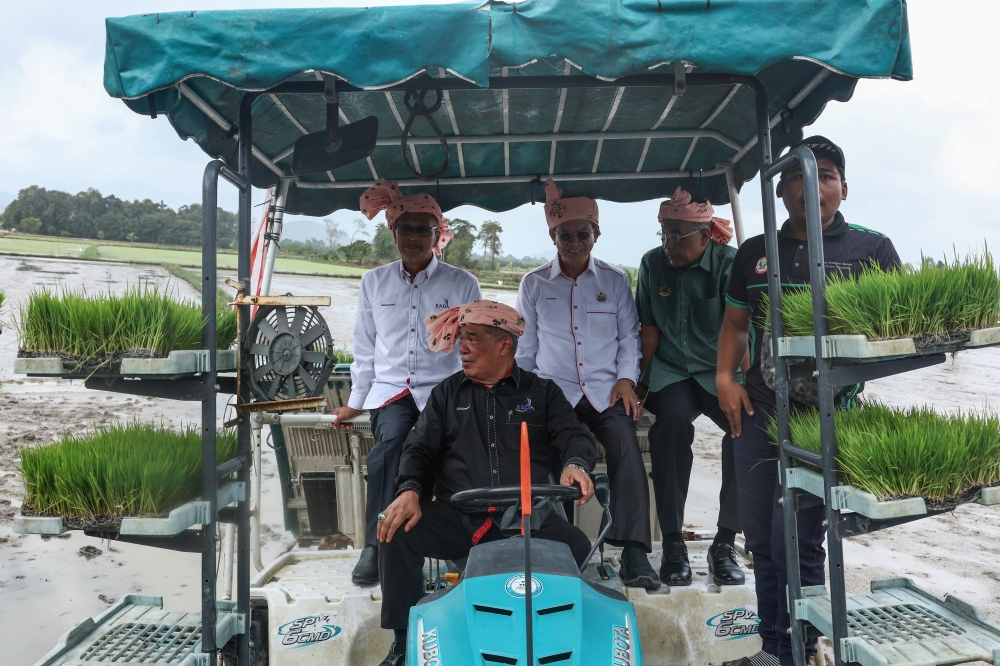 Minister of Agriculture and Food Security Datuk Seri Mohamad Sabu drives a paddy planting machine during the launch of the SMART SBB Ala Sekinchan Project in Bendang Tok Ajam January 28, 2024. — Bernama pic
