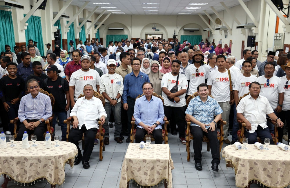 Prime Minister Datuk Seri Anwar Ibrahim (seated centre) poses for a picture with the participants of the Northern Economic Corridor Regional Farmers Initiative after visiting the IPR-Intan NCER project site at Bahagia Hulu Kinta Hospital January 28, 2024. — Bernama pic