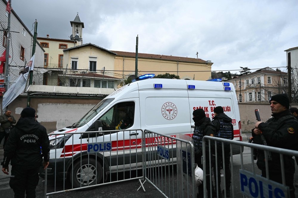 An ambulance leaves from Santa Maria church as Turkish anti riot police officers block the street after an attack in Istanbul January 28, 2024. — AFP pic