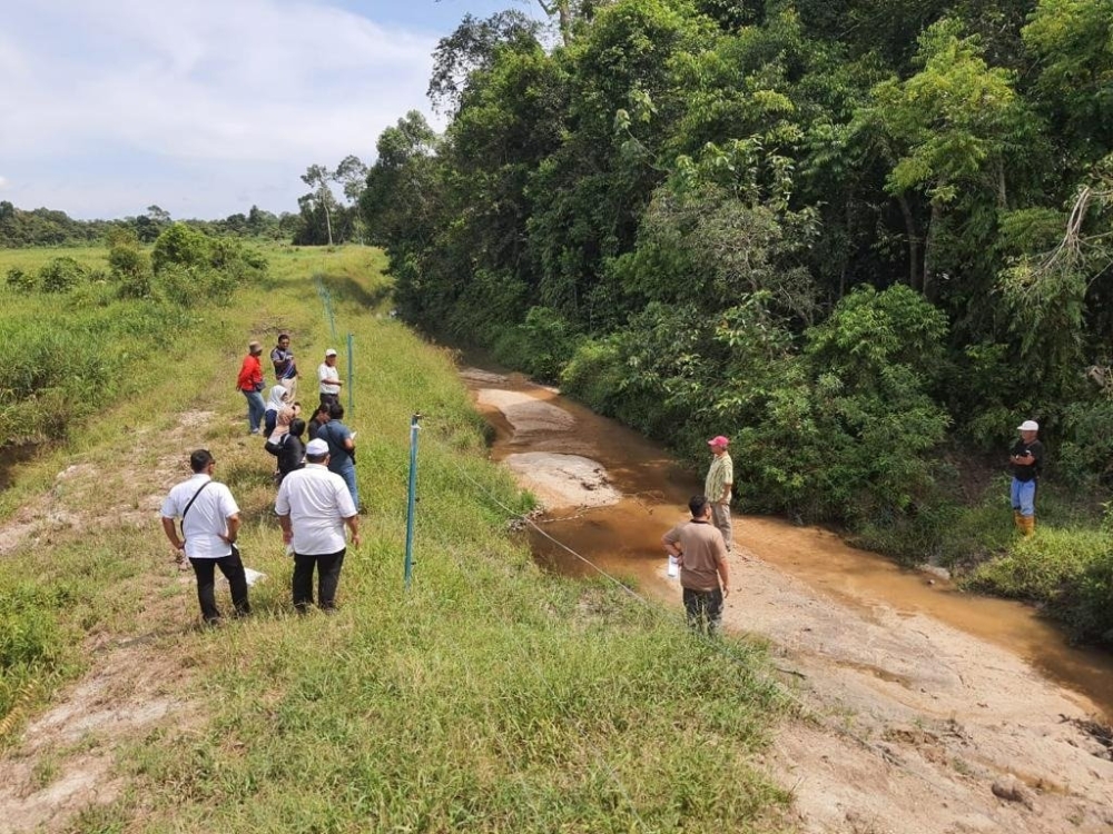 MPOCGF and EF helping Sungai Ara farmers build an electric fence to keep out wild elephants. — Picture courtesy of MPOCGF