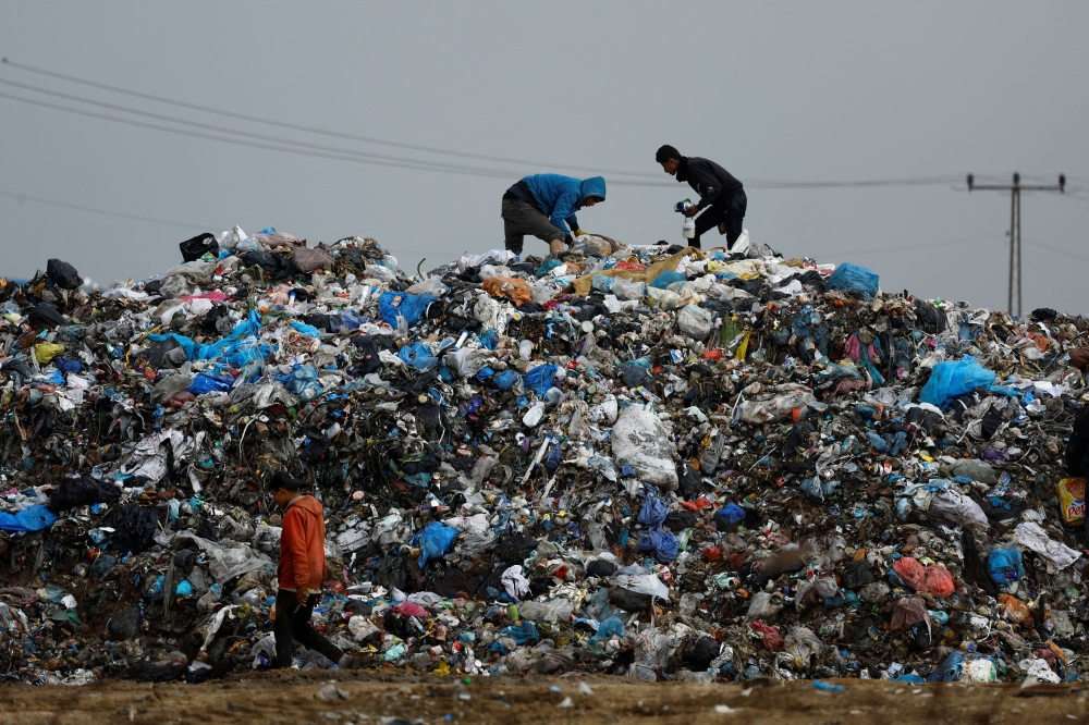Palestinians look through garbage, amid the ongoing conflict between Israel and Palestinian Islamist group Hamas, in Rafah, southern Gaza Strip January 29, 2024. — Reuters pic