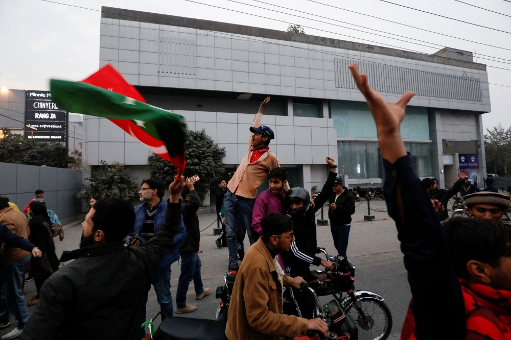 Supporters of former Pakistani Prime Minister Imran Khan chant slogans as they run after police dispersed them during a rally ahead of the general elections in Lahore, Pakistan January 28, 2024. ― Reuters pic