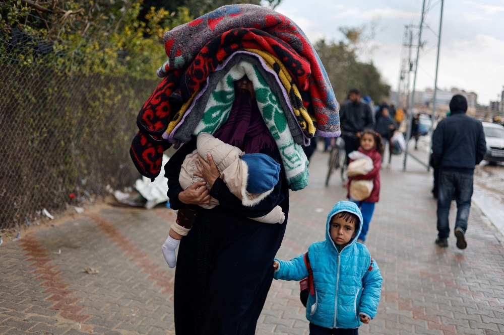 A woman holds a baby as Palestinians fleeing Khan Younis, due to the Israeli ground operation, move towards Rafah, amid the ongoing conflict between Israel and the Palestinian Islamist group Hamas, in the southern Gaza Strip, January 29, 2024. — Reuters pic