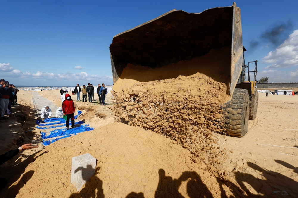 People bury Palestinians, who were killed in Israeli strikes and fire, after their bodies were released by Israel, amid the ongoing conflict between Israel and the Palestinian Islamist group Hamas, at a mass grave in Rafah, in the southern Gaza Strip, January 30, 2024. — Reuters pic