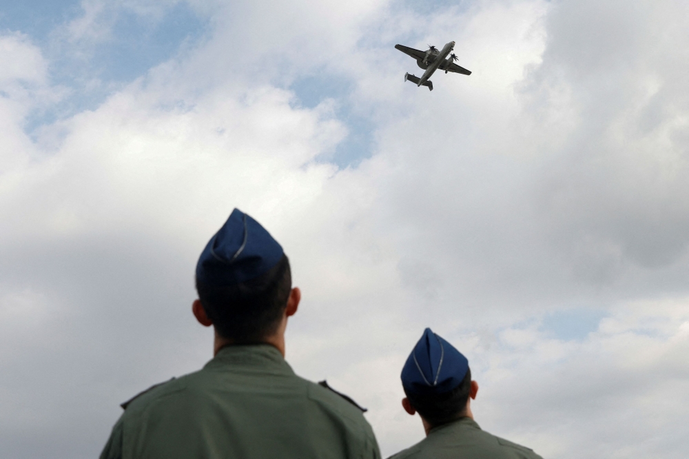 Members of the Taiwan Air Force look on as an E-2K aircraft flies past during a demonstration for the media at the Pingtung air base in Pingtung, Taiwan January 30, 2024. — Reuters pic