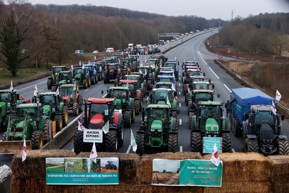 French farmers block a highway with their tractors during a protest over price pressures, taxes and green regulation, grievances shared by farmers across Europe, in Longvilliers, near Paris, France, January 30, 2024. — Reuters pic
