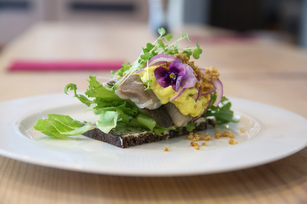 Marinated Herring smørrebrød is a classic must-eat here with the pickled fish paired with a curry spiced mayonnaise and diced eggs 