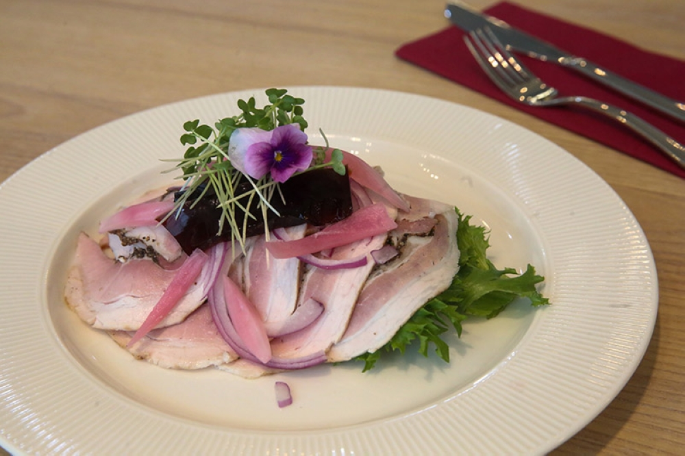 Rullepøise smørrebrød is paired with pickled onions and the jelly-like aspic which gives it a slight sweetness