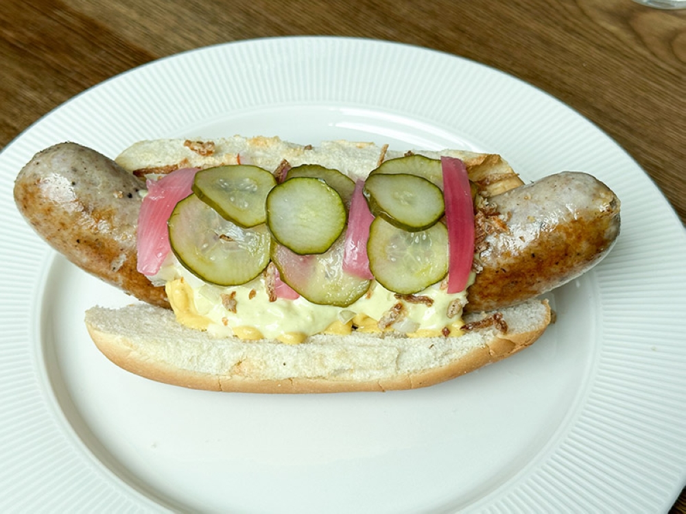 Hotdogs are a big thing in Denmark and in Denhygge, they make their own farmer sausage hotdog served with fluffy bread, marinated onions, mustard, pickled mayonnaise, marinated cucumbers and fried onions