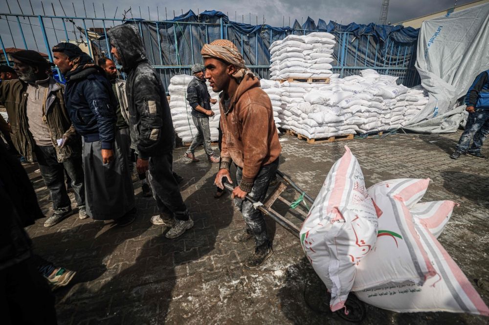 Displaced Palestinians receive food aid at the United Nations Relief and Works Agency for Palestine Refugees (UNRWA) centre in Rafah on January 28, 2024. — AFP pic