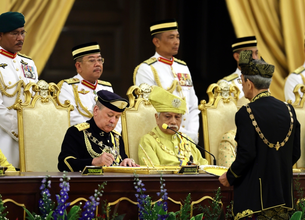 Sultan Ibrahim (seated, left) signs the proclamation of assuming the office of the 17th Yang di-Pertuan Agong at the Istana Negara in Kuala Lumpur January 31, 2024. — Bernama pic