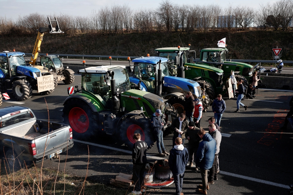 French farmers park their tractors on the A1 highway, at a law enforcement checkpoint near Roissy Charles-de-Gaulle airport, during a protest over price pressures, taxes and green regulation, grievances shared by farmers across Europe, in Chennevieres-les-Louvres, near Paris January 31, 2024. — Reuters pic  
