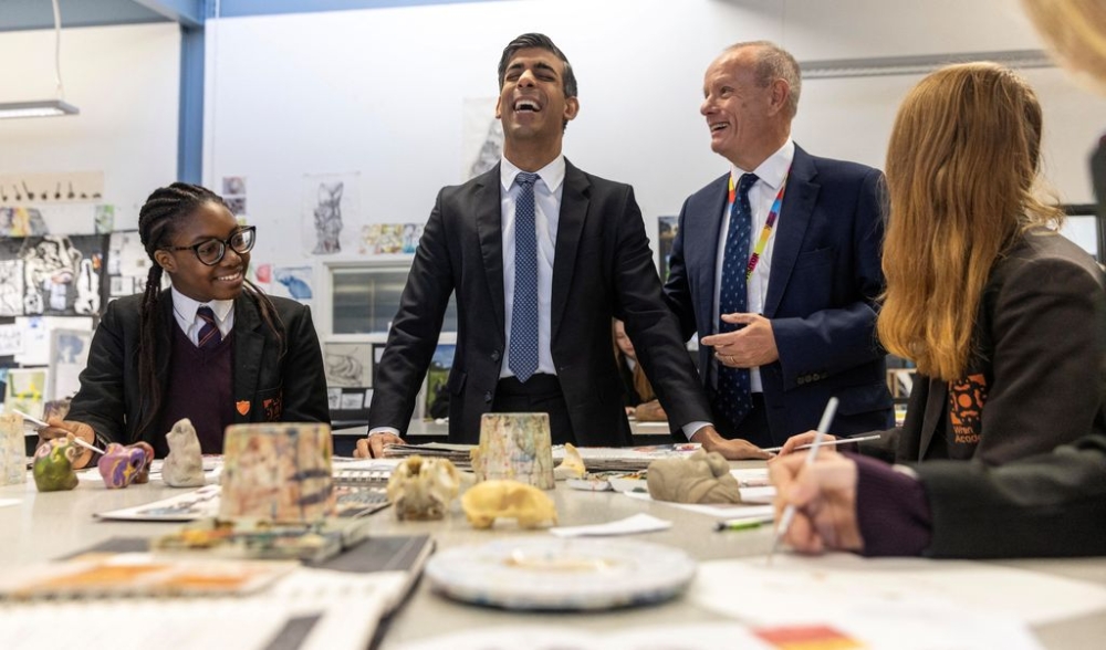 British Prime Minister Rishi Sunak laughs at a joke said by local Member of Parliament Mike Freer as he talks with pupils in a year ten art class in Wren Academy school in Finchley, north London, Britain December 14, 2023. — Pool pic via Reuters