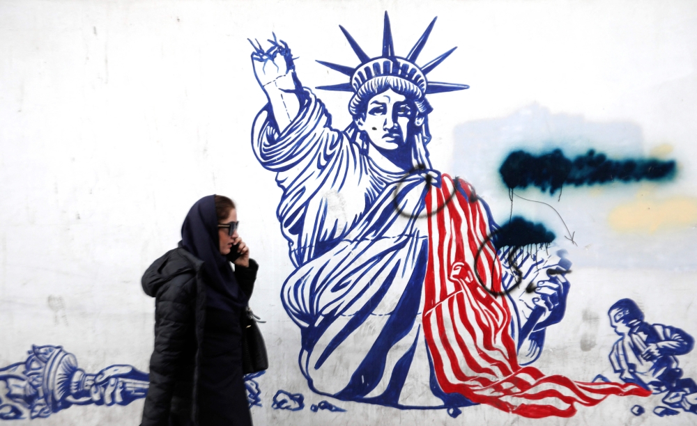 A woman walks past anti-US graffiti outside the building formerly hosting the embassy of the United States in Tehran — today known as the ‘Den of Spies’ museum — on January 30, 2024, amid tensions between Iran and the US over the regional repercussions of the ongoing Israeli-Palestinian conflict. — AFP pic