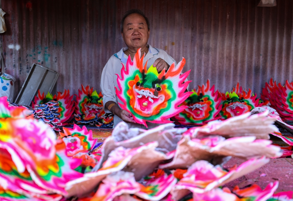 Ong Chin Chye, 64, shows a dragon head that will be attached to a joss stick. — Bernama pic