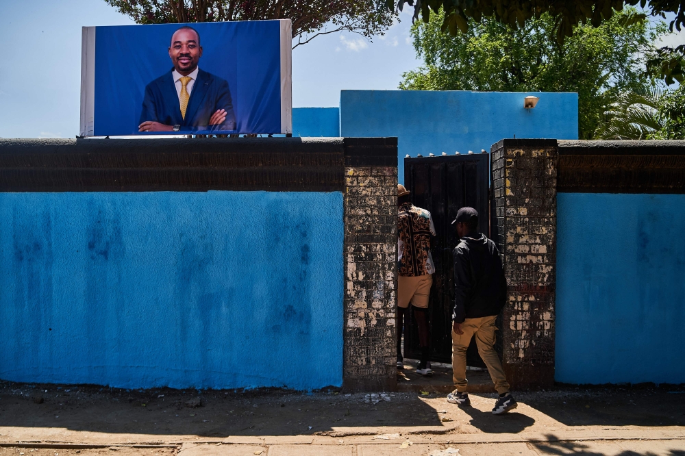 Youth arrive at the Citizens Coalition for Change (CCC) offices in Bulawayo on January 30, 2024 where youth aligned to Nelson Chamisa, Zimbabwe's main opposition leader, erected a banner and painted the CCC office walls blue in solidarity after Chamisa recently quit his own party. — AFP pic