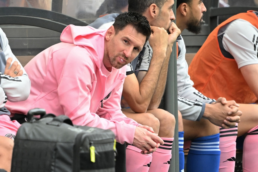 Inter Miami's Argentine forward Lionel Messi (left) sits on the bench during the friendly football match between Hong Kong XI and US Inter Miami CF in Hong Kong February 4, 2024. — AFP pic