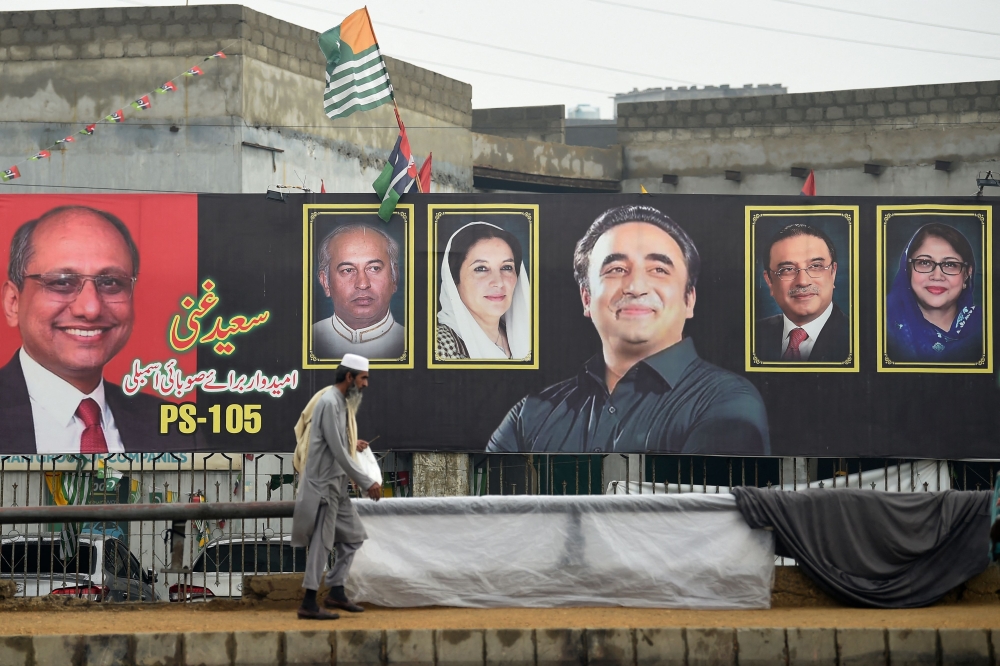 A man walks past an election banner displaying Bilawal Bhutto Zardari (C), chairman of Pakistan Peoples Party (PPP), along a street in Karachi on February 4, 2024, ahead of the upcoming general elections. — AFP pic