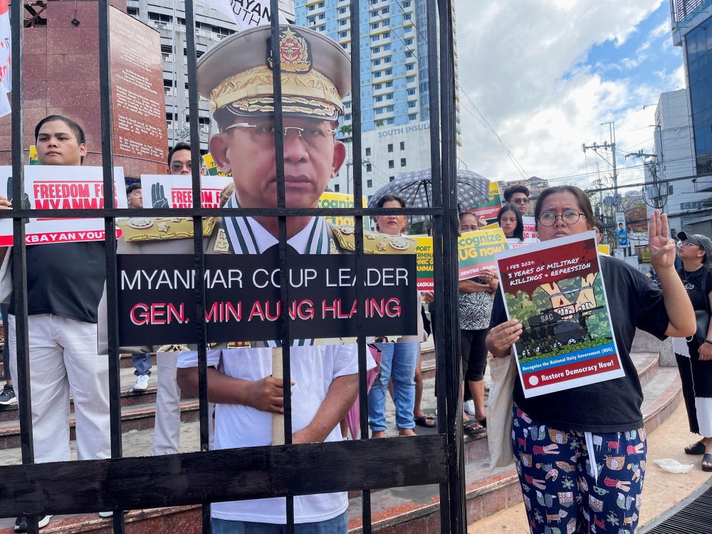 A Filipino protestor holds a three finger salute next to a cut out of Myanmar’s junta chief Min Aung Hlaing during a rally to mark the third year anniversary of Myanmar’s 2021 military coup in Manila. — Reuters pic