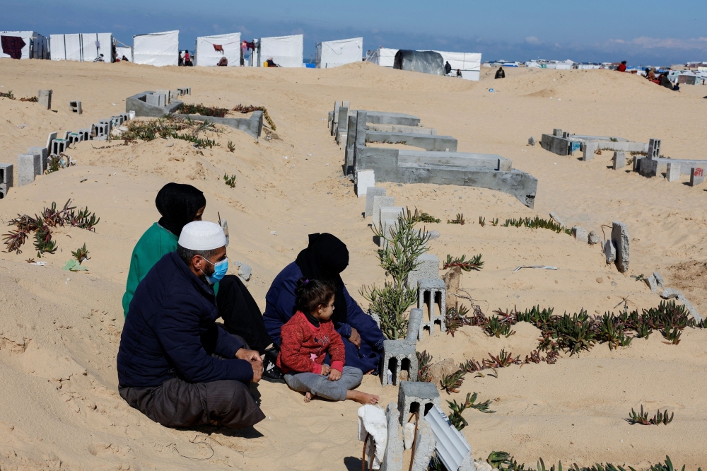 Displaced Palestinians, who fled their houses due to Israeli strikes, shelter in a cemetery, amid the ongoing conflict between Israel and Hamas, in Rafah in the southern Gaza Strip, February 5, 2024. — Reuters pic