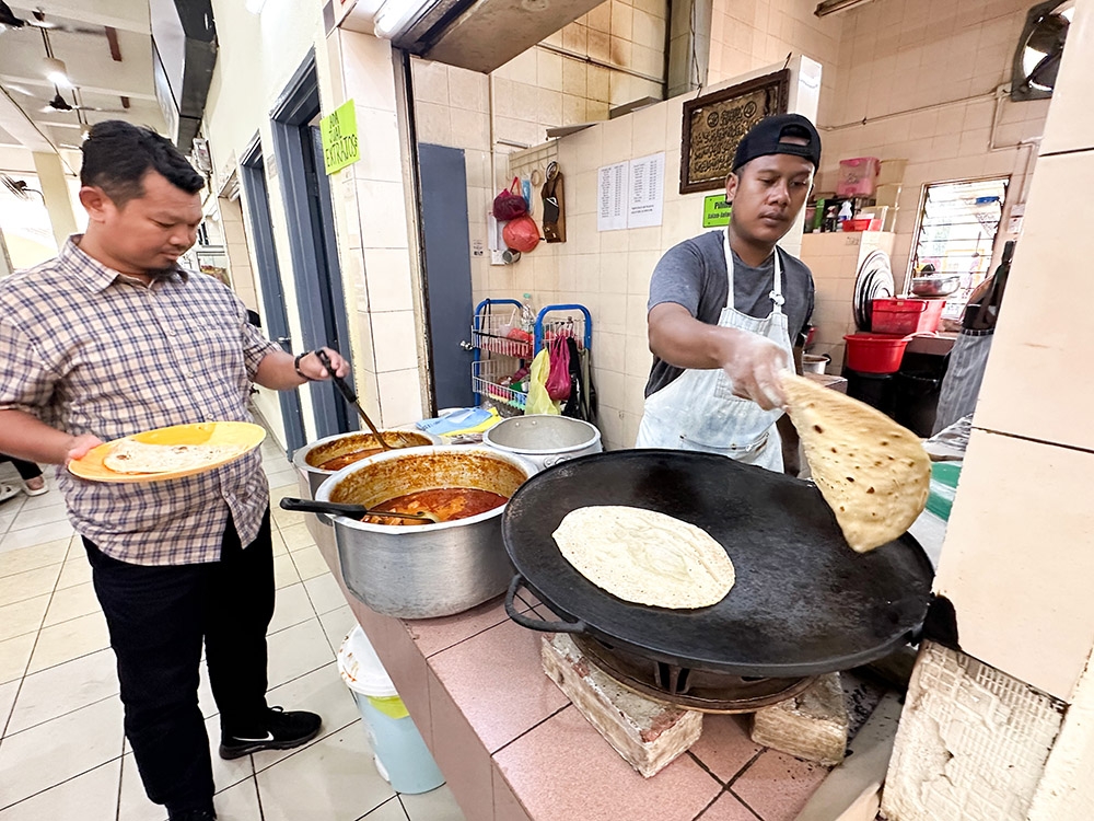 Wait at the counter for freshly-made 'chapati' to be eaten with your choice of curry.