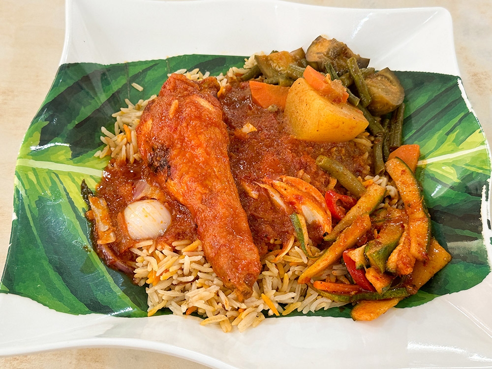 Fuel up with a plate of biryani rice, 'ayam masak merah', 'dalca' and 'acar'.