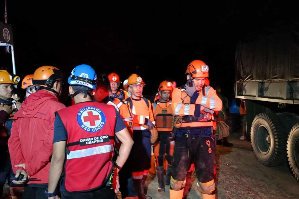 At least 11 people were injured when a rain-induced landslide buried two buses picking up workers from a gold mine in the southern Philippines, officials said. — AFP pic/Philippine Red Cross-Davao de Oro Chapter