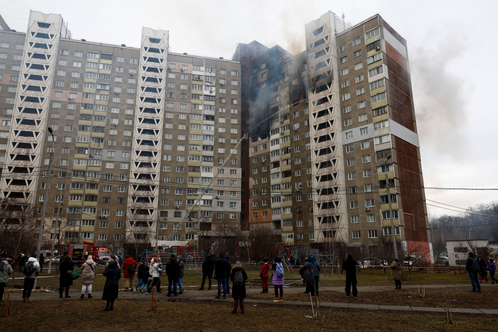 Local residents watch firefighters work at a site of a building damaged during a Russian missile strike, amid Russia's attack on Ukraine, in Kyiv, Ukraine February 7, 2024. — Reuters pic