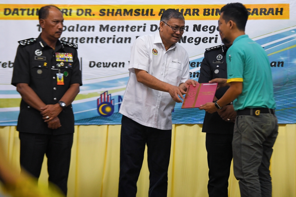 Deputy Home Minister Datuk Seri Shamsul Anuar Nasarah (2nd left) hands out a Prison Visitation Rights Letter to a recipient during the Ihsan Madani Prisoners’ Release event in conjunction with the 2024 Chinese New Year in Seremban February 7, 2024. — Bernama pic