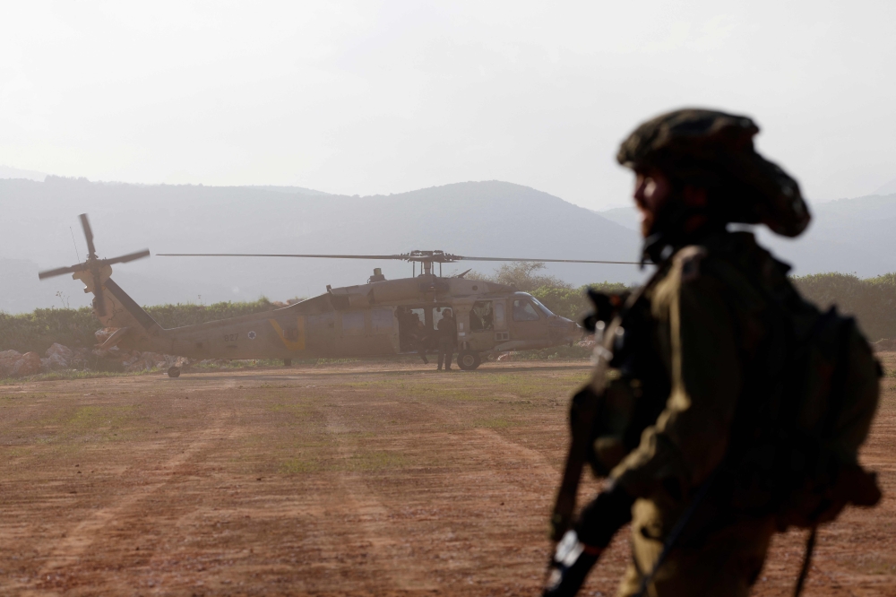 An Israeli soldier looks on as a helicopter takes off during a military exercise in Upper Galilee near the Lebanon border on February 7, 2024, amid ongoing battles between Israel and Palestinian Hamas militants in the Gaza Strip. — AFP pic