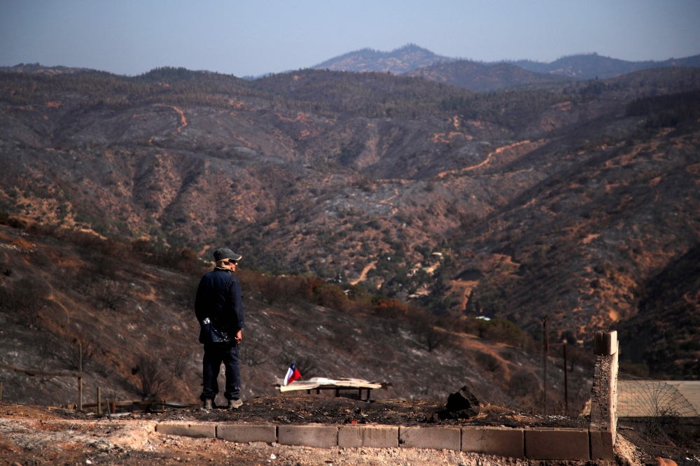 A man observes the aftermath of a forest fire in Poblacion Pompeya Sur, Quilpue, Chile on February 6, 2024. — AFP pic