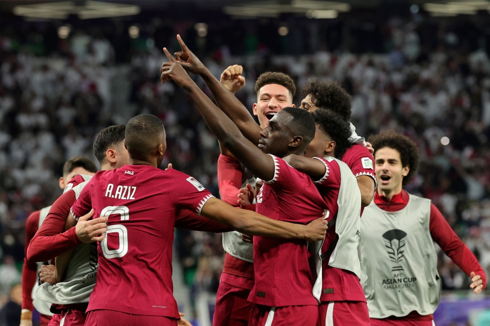 Qatar's forward #19 Almoez Ali (C) celebrates with teammates after scoring his team's third goal during the Qatar 2023 AFC Asian Cup semi-final football match between Iran and Qatar at al-Thumama Stadium in Doha on February 7, 2024. — AFP pic