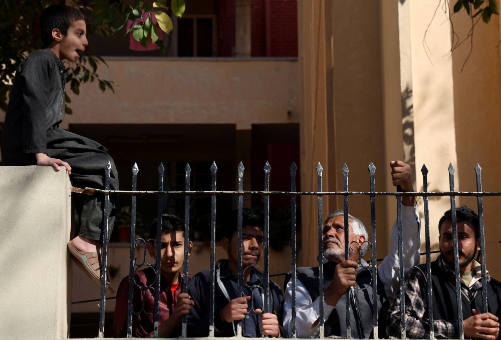People watch as Pakistan Tehreek-e-Insaf (PTI) supporters protest outside a temporary election commission office demanding free and fair results of the election, in Islamabad, Pakistan February 9, 2024.   — Reuters pic