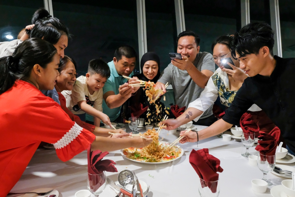 Nur Allyshia Low Kim Choon, 30, (4th left) and her parents and family during reunion dinner in Kuantan, Pahang, February 9, 2024. — Bernama pic 