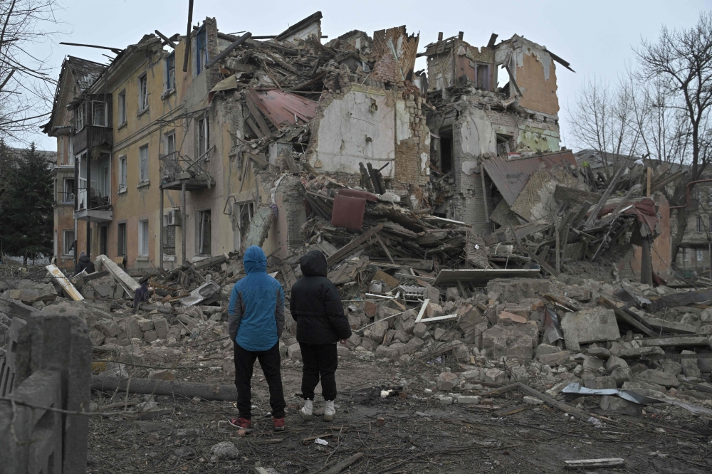 Local residents stand among debris of a residential building partially destroyed by a missile attack in the town of Selydove, Donetsk region, on February 8, 2024, amid the Russian invasion of Ukraine. — AFP pic