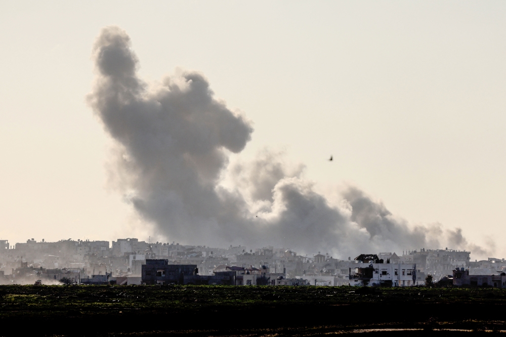 A picture taken from southern Israel on February 9, 2024 shows smoke rising above destroyed buildings in the Gaza Strip, amid ongoing battles between Israel and the Palestinian militant group Hamas. — AFP pic
