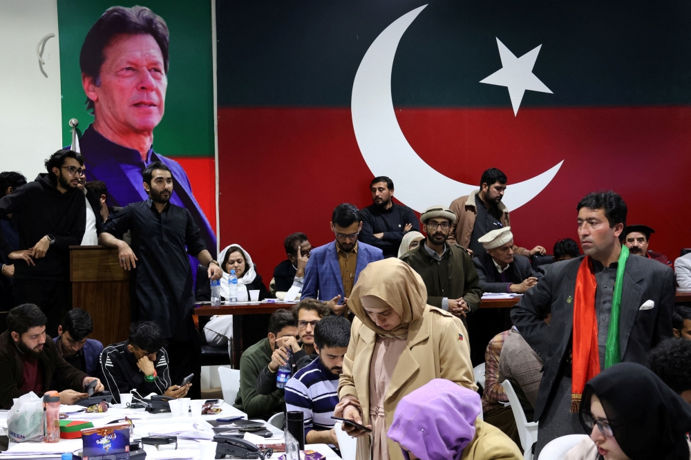 Volunteers for former Prime Minister Imran Khan’s party Pakistan Tehreek-e-Insaf (PTI) look on as they watch results on TV screens after the end of the polling during a general election at the party’s main office in Islamabad, Pakistan, February 8, 2024. — Reuters pic