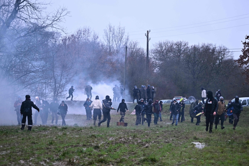 Protesters face off with French gendarmes in a cloud of teargas, in a field near the ‘Zone to be Defended’ (ZAD) camp during a demonstration against the A69 motorway project between Toulouse and Castres, in Saix, southwestern France, on February 10, 2024. — AFP pic