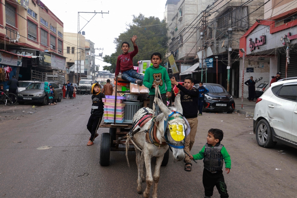 Children ride a donkey-pulled cart along a street in Rafah in the southern Gaza Strip on February 9, 2024, amid the ongoing conflict between Israel and the Palestinian militant group Hamas. — AFP pic