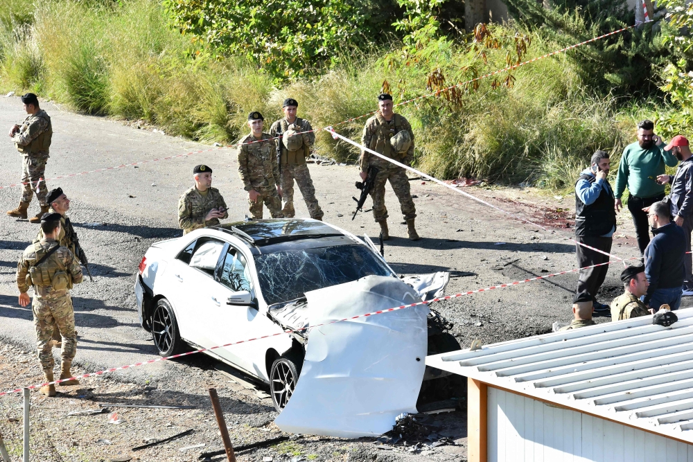 Lebanese army soldiers secure the area around a car wrecked in a reported Israeli drone strike in the village of Jadra between Beirut and the southern city of Sidon, on February 10, 2024. — AFP pic