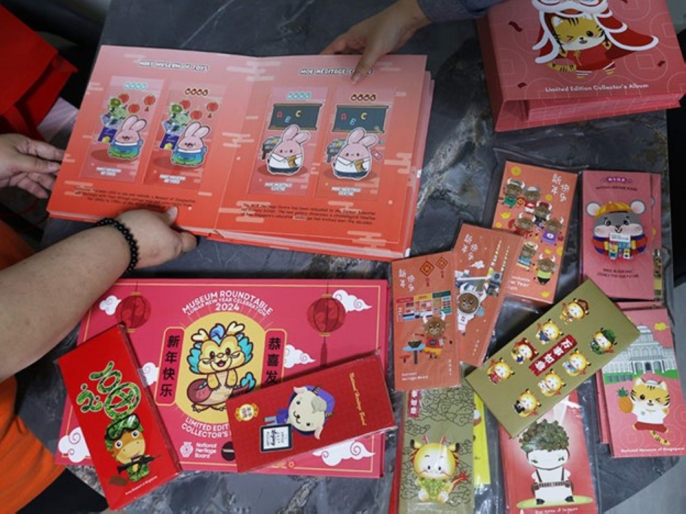 Red packet collector Sally Ng showing her collection of museum-themed red packets. — TODAY pic