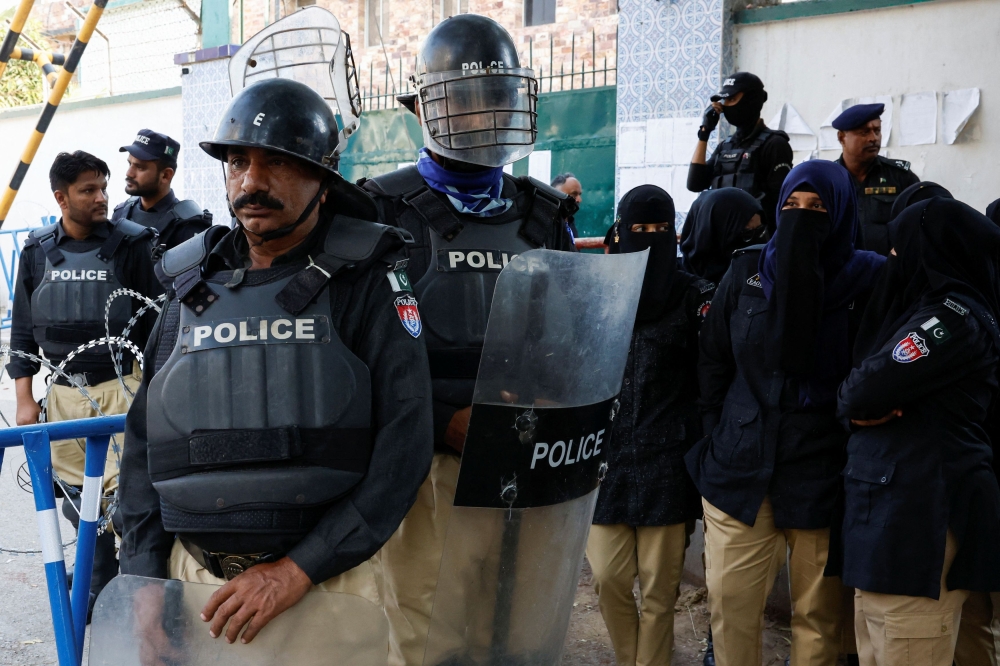 Police officers stand guard during a protest by the supporters of the former Prime Minister Imran Khan's party Pakistan Tehreek-e-Insaf (PTI) and the religious and political party Jamat-e-Islami (JI) demanding free and fair results of the elections, outside the provincial Election Commission of Pakistan (ECP) building in Karachi, Pakistan February 10, 2024. — Reuters pic