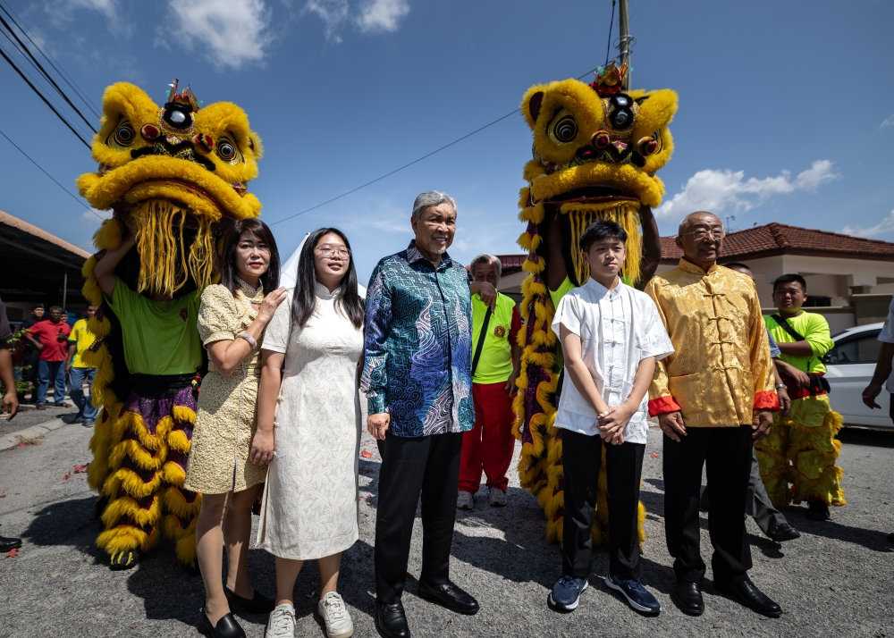 Deputy Prime Minister Datuk Seri Ahmad Zahid Hamidi poses for a picture with his adopted Chinese family Beh Song Wan, his wife Tian Mee Ping and their two children at Taman Desa Bersatu, Hutan Melintang February 11, 2024. — Bernama pic