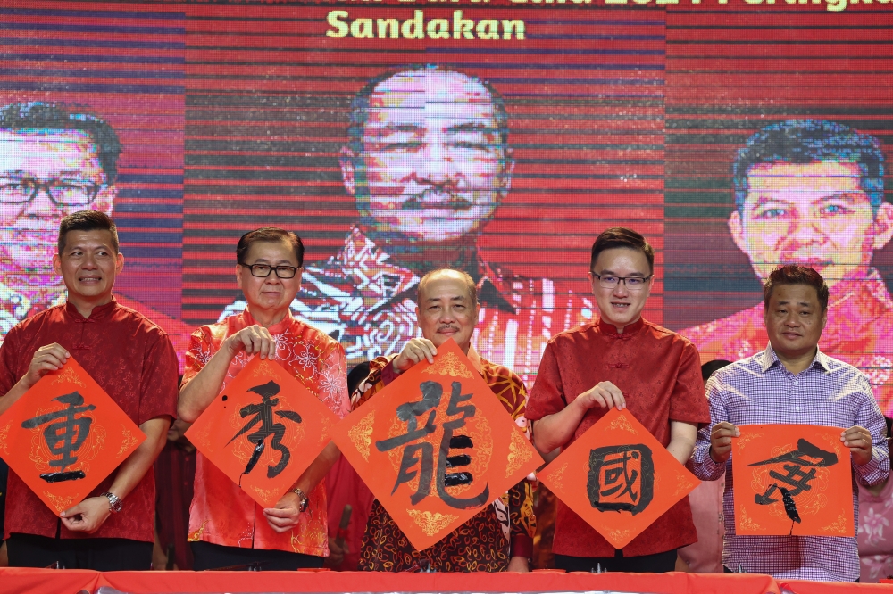 Sabah Chief Minister Datuk Seri Hajiji Noor (centre) shows Chinese calligraphy he wrote at a Chinese New Year 2024 open house for Sandakan district February 11, 2024. — Bernama pic
