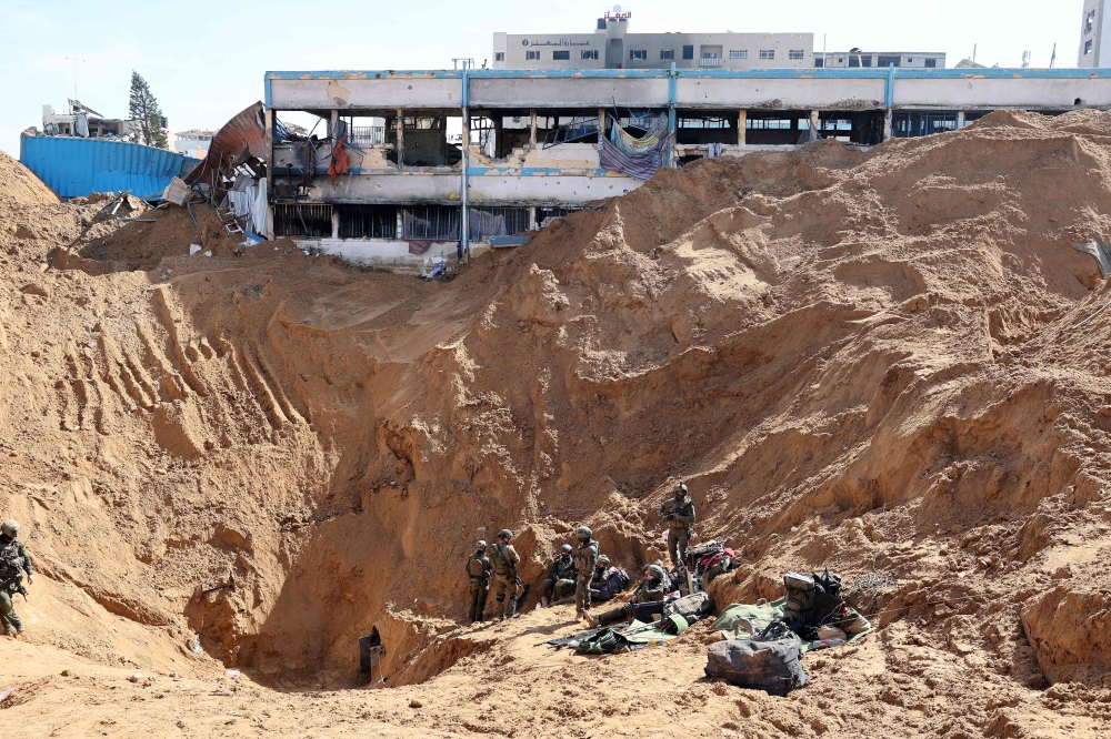 This picture taken during a media tour organised by the Israeli military on February 8, 2024, shows Israeli soldiers at the entrance of a tunnel in Gaza. — AFP pic